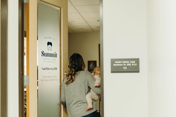 Patient with baby entering the Summit Dental Care office